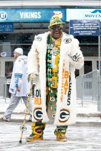 Yes, he might be dressed like a pimp in his Green Bay Packers regalia. However, at least he's dressed for the weather because it's snowing in this picture.