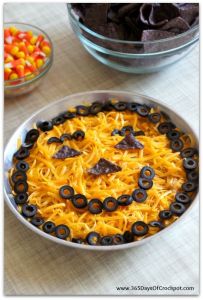 This looks quite adorable if I do say so myself. Not sure about the layers. But the top consists of shredded cheddar, olives, and blue tortilla chips.
